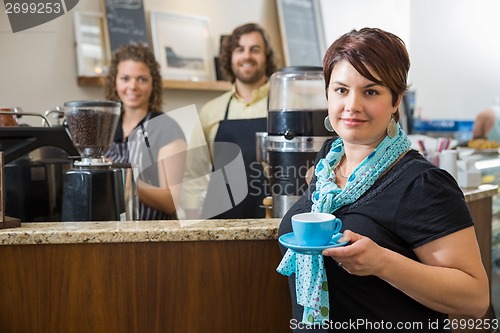 Image of Customer Holding Coffee Cup With Workers At CafÃ©