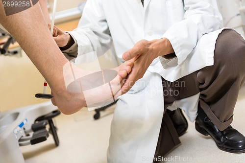 Image of Doctor Examining Patient's Foot In Hospital