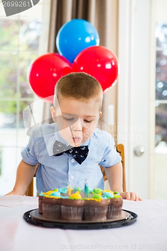 Image of Boy Blowing Candles On Cake