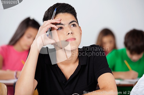 Image of Thoughtful Boy Looking Up In Classroom