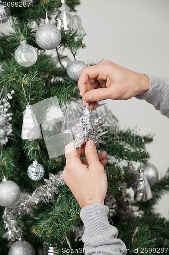 Image of Man Decorating Christmas Tree