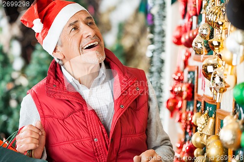 Image of Man Selecting Christmas Ornaments At Store