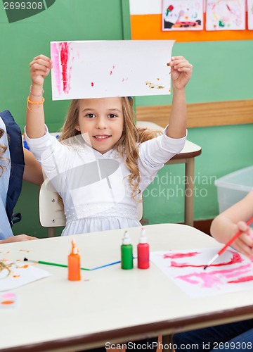 Image of Girl Showing Painting At Classroom Desk