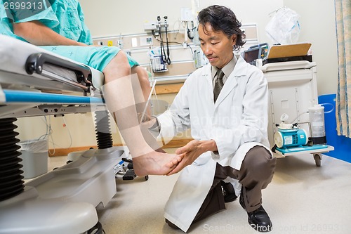 Image of Neurologist Examining Patient's Reflexes