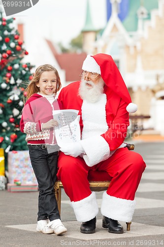 Image of Happy Girl Giving Letter To Santa Claus