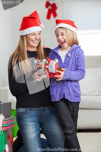 Image of Cheerful Daughter And Mother With Christmas Present