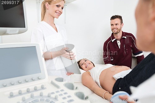 Image of Doctor Showing Digital Tablet To Expectant Couple