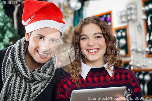 Image of Couple With Digital Tablet At Christmas Tore