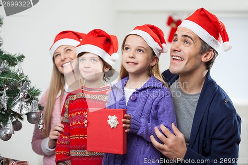 Image of Family In Santa Hat With Christmas Present