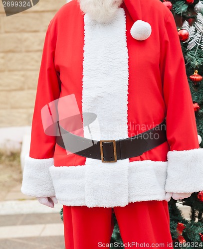 Image of Santa Claus Standing Against Tree