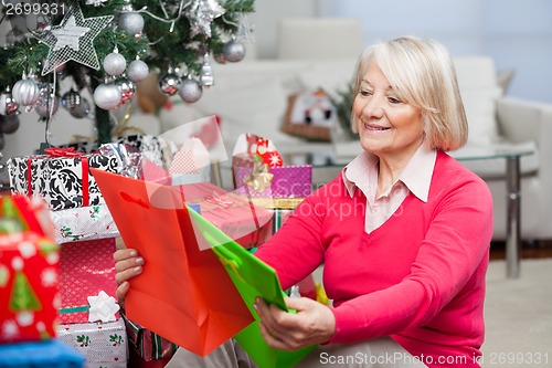 Image of Smiling Senior Woman Choosing Bags