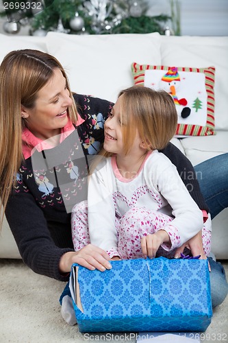 Image of Smiling Daughter And Mother Opening Christmas Gift