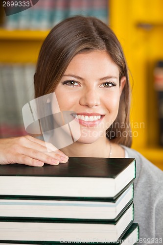 Image of Beautiful Woman With Piled Books Smiling In Library