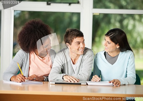 Image of Students Looking At Friend While Sitting In Classroom