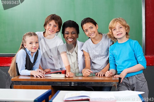 Image of Teacher With Schoolchildren At Desk In Classroom