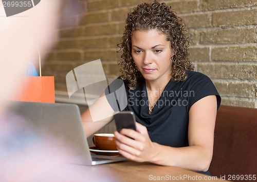 Image of Woman Texting in Cafe