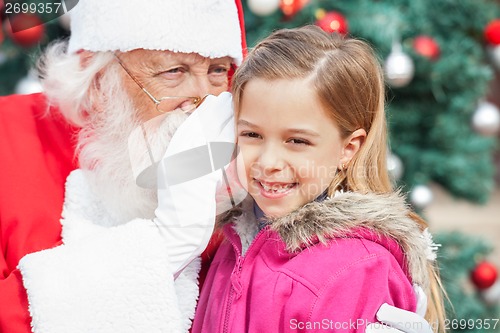 Image of Santa Claus Whispering In Happy Girl's Ear