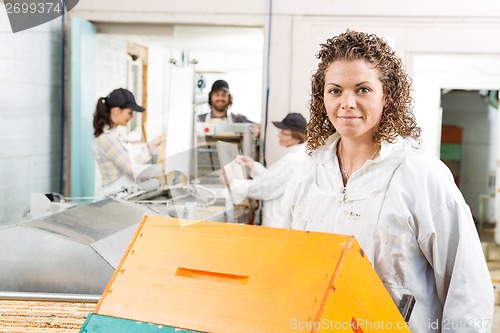 Image of Female Beekeeper With Stacked Honeycomb Crates