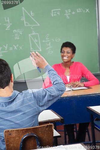 Image of Schoolboy Raising Hand While Teacher Looking At Him