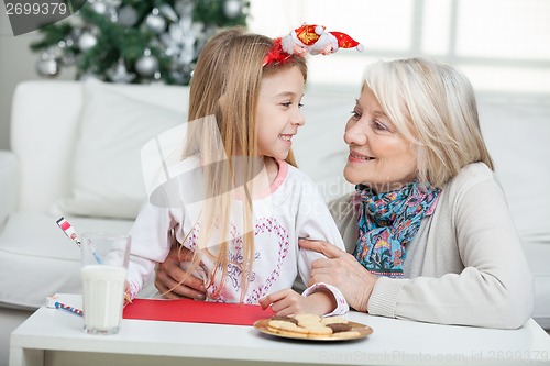 Image of Grandmother And Girl With Cardpaper Looking At Each Other