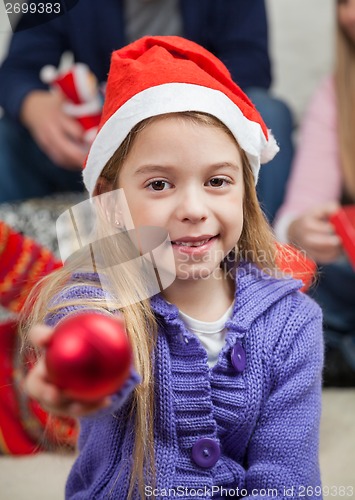 Image of Smiling Girl Showing Christmas Ornament
