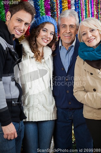 Image of Family Standing Against Tinsels At Store