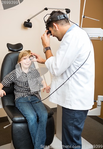 Image of Optician Examining Boy's Eye Through Lens