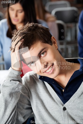 Image of Man With Hand In Hair Smiling At Classroom