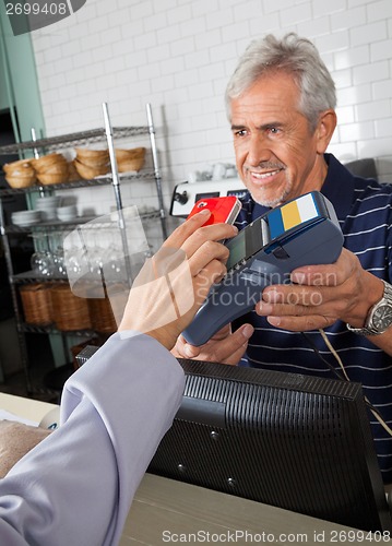 Image of Customer Paying Through Mobile Phone In Store