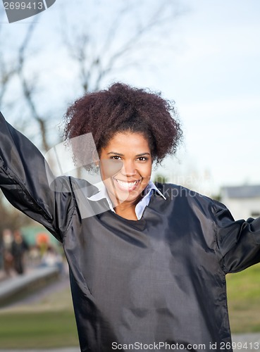 Image of Happy Woman In Graduation Gown On Campus