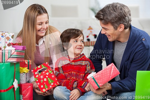 Image of Parents With Christmas Presents Looking At Son