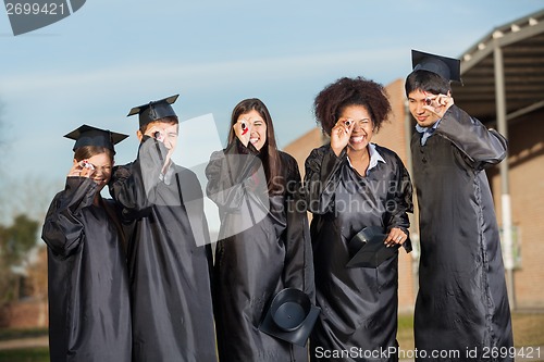 Image of Graduate Students Looking Through Diplomas On Campus