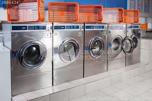 Image of Washing Machines And Empty Baskets In A Row