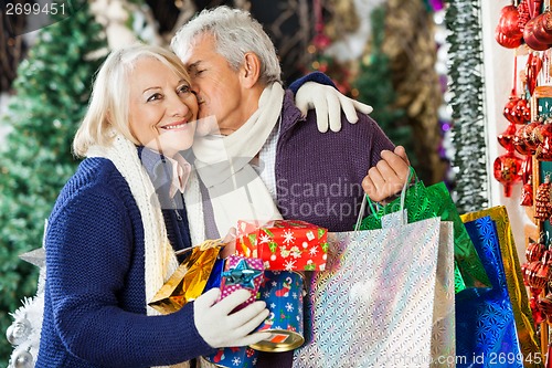 Image of Man With Shopping Bags Kissing Woman At Store