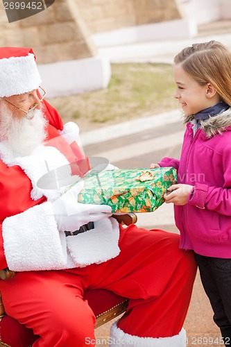 Image of Girl Receiving Present From Santa Claus