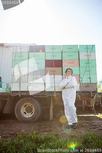 Image of Beekeeper Standing Against Truck Loaded With Honeycomb Crates