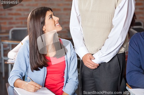 Image of Student Looking At Teacher While Giving Exam In Classroom