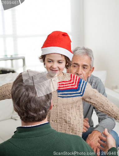 Image of Son In Santa Hat About To Embrace Father