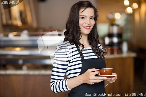 Image of Beautiful Waitress Holding Coffee Cup In Cafeteria