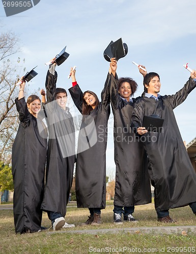 Image of Students With Diplomas Celebrating Success On Graduation Day At