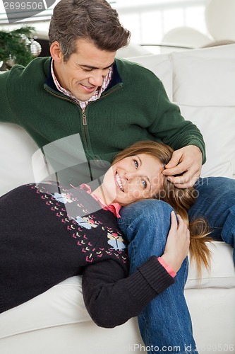 Image of Couple Relaxing On Sofa During Christmas