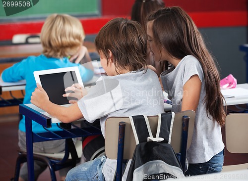 Image of Schoolchildren Using Digital Tablet In Classroom
