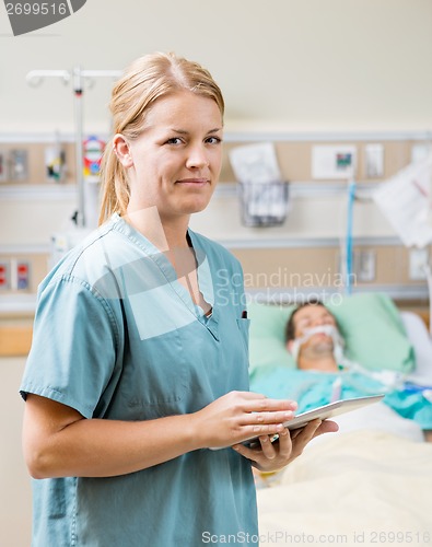 Image of Nurse Holding Digital Tablet With Patient Resting In Hospital