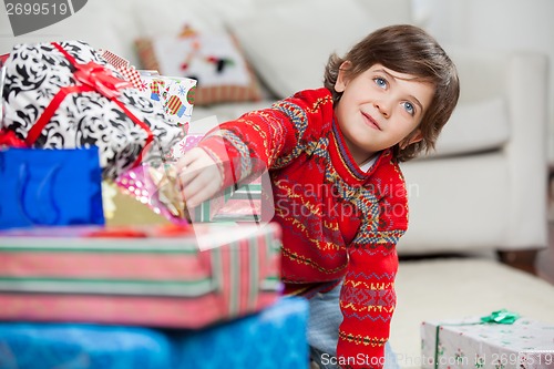 Image of Boy Taking Christmas Gift From Stack