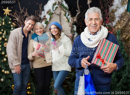 Image of Happy Family With Christmas Presents And Shopping Bags At Store