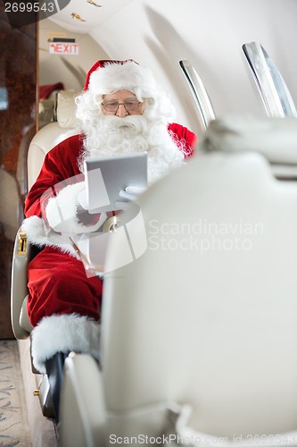 Image of Santa Using Tablet Computer In Private Jet