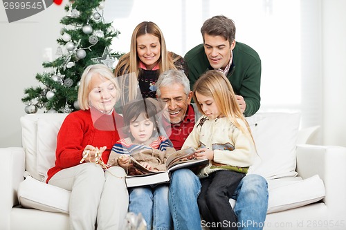 Image of Family Reading Book Together In House