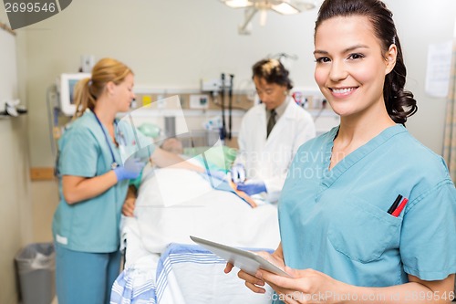 Image of Nurse With Digital Tablet While Doctor And Colleague Operating P