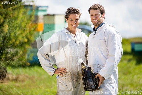 Image of Beekeepers With Smoker Standing At Apiary