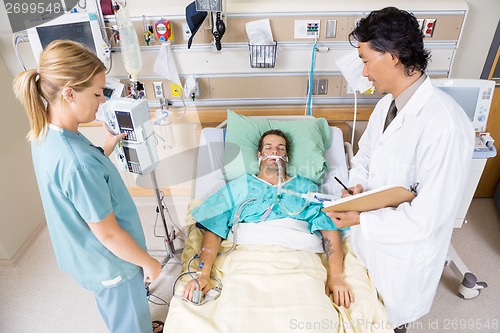 Image of Doctor And Nurse Examining Critical Patient